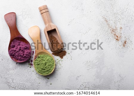 Matcha tea, cinnamon powder and acai berry powder in bamboo spoons. Top view of superfoods and spice Royalty-Free Stock Photo #1674014614