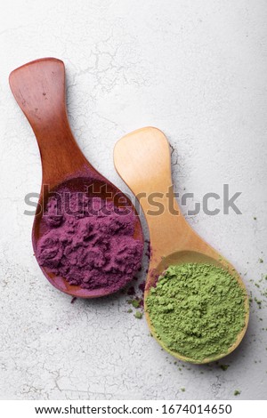 Matcha tea and acai berry powder in bamboo spoons. Top view Royalty-Free Stock Photo #1674014650