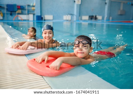 Children swimming group poses at the poolside