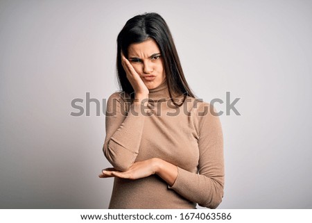 Young beautiful brunette woman wearing turtleneck sweater over white background thinking looking tired and bored with depression problems with crossed arms.