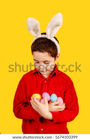 Glorious child in bunny ears headband holding Golden Easter eggs