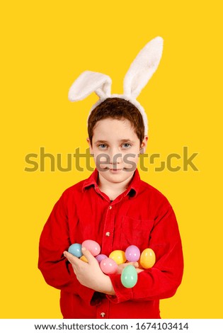 Adorable child in bunny ears headband holding Golden Easter eggs