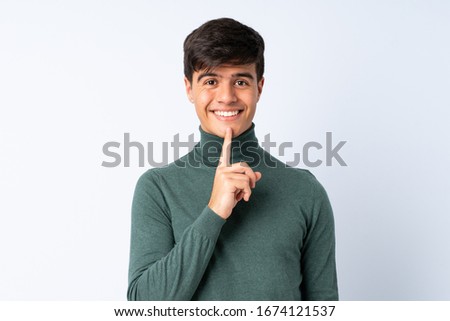 Handsome man over isolated blue background showing a sign of silence gesture putting finger in mouth