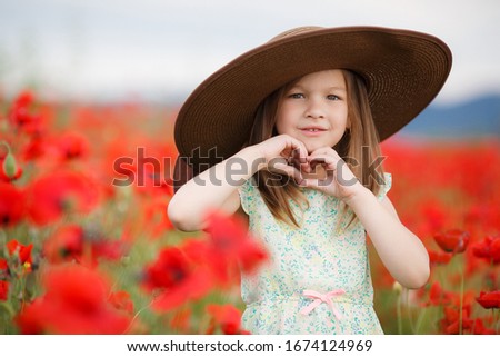 Cute child girl in poppy field. very happy kid in poppies. Girl in poppies. happiness and freedom. beautiful nature
