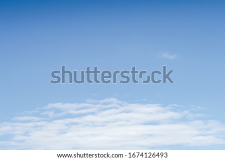 Cirrus clouds on the blue sky. Blue background with white spots. The sky in the afternoon.
