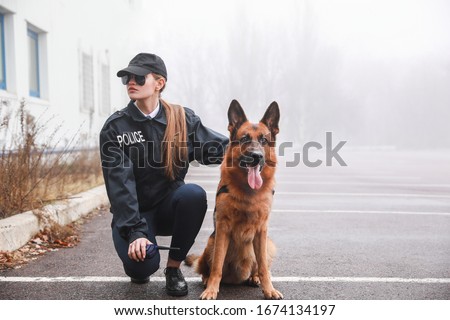 Female police officer with dog patrolling city street Royalty-Free Stock Photo #1674134197