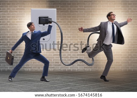 Businessman being powered by electricity and plug