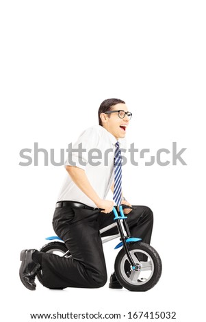 Excited young businessperson riding a small bicycle isolated against white background
