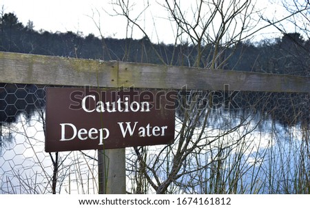 A wooden sign warning of Deep Water at a lake in Scotland 