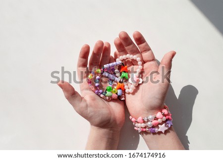bead bracelets. beads in the hands. decorations. bijouterie. hobbies of girls. rings. background
