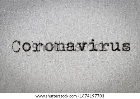 Coronavirus typewrite on paper, close-up. Warning type text of infectious disease