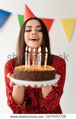 young beautiful girl blows out the candles on the cake.
