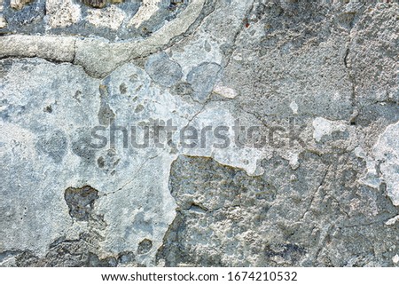 Destroyed chipped wall of sea house. Bright light exterior town facade. Whitewashed ruined structure background. Grunge uneven old stone rock texture. Outside crack crash cement mortar for 3d design