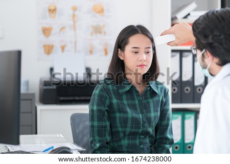 Doctor Checking Temperature Using Infrared Thermometer for Asian patients Royalty-Free Stock Photo #1674238000