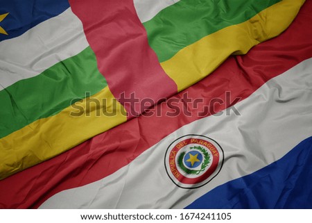 waving colorful flag of paraguay and national flag of central african republic. macro