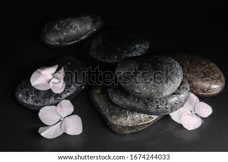 Stones and flowers in water on grey background. Zen lifestyle