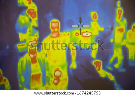 Thermal scanner / camera detecting infected people with Covid-19. Group of people under thermal imaging camera. Modern airport checking system. Royalty-Free Stock Photo #1674245755