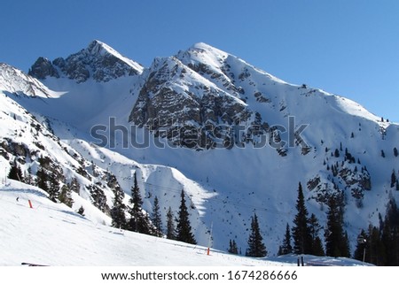 Triple peak under a snow blanket. Alps