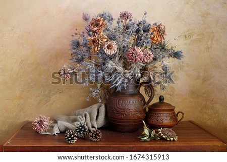 Bouquet of dried flowers in a vase on the table .
