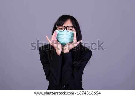 Asian woman masked a protective mask and showing trumb up sign.