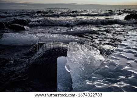 Waves entering icy rocky shore a cold day. Shot taken by the Baltic northern sea, Sweden.
