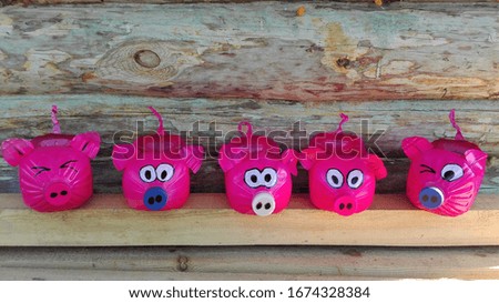  Garden decor in the form of bright pink pigs on the background of logs