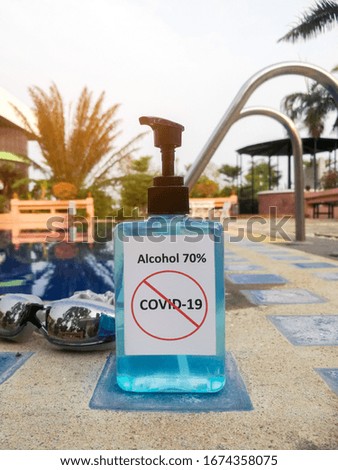 Alcohol 70% Sanitizer standing side of the swimming pool for protect corona virus or covid-19