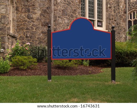 blank sign by a stone church and grass lawn