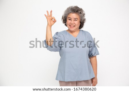 Portrait of happy senior asian woman gesture or showing hand ok and looking at camera isolated on white background, Older female feeling positive and enjoy concept