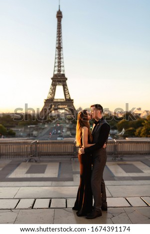 Romantic couple kisses near the Eiffel tower. Love, date, honeymoon in Paris