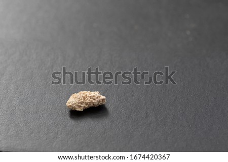 5 mm kidney stone laying on black background
