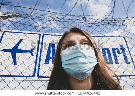 coronavirus global fight concept - COVID-19 - woman wearing face mask and airport sign
