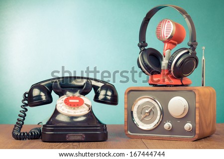Retro rotary telephone, radio, headphones, microphone on table