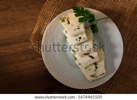 Sliced herby cheese served in a white plate  Royalty-Free Stock Photo #1674465505