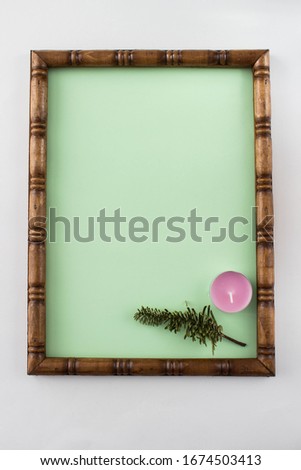 Wooden carved frame with a green background inside (place for text) decorated with candles and branch.