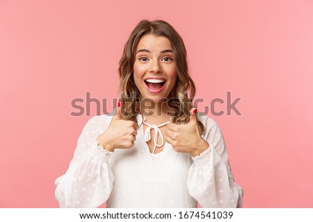 Close-up portrait of satisfied and impressed blond girl leave positive feedback about cafe or place she was attending, show thumbs-up in like and approval, smiling pleased, pink background Royalty-Free Stock Photo #1674541039