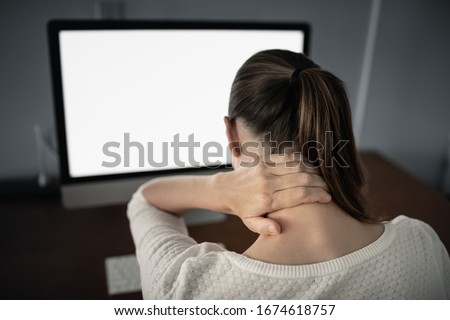Neck ache concept. Young woman sitting at office desk feeling hurt having pain in her neck.Woman massaging rubbing stiff sore neck tensed muscles, fatigued from computer work and incorrect posture. Royalty-Free Stock Photo #1674618757
