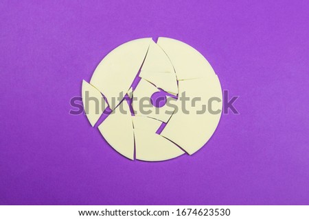 White broken disc on color background