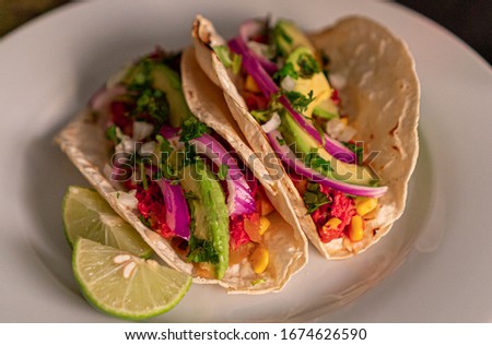 Mexican-style marlin tacos prepared with avocado, onion, and coriander with a glass of wine
