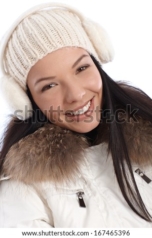 Closeup portrait of smiling young woman dressed up warm at wintertime.