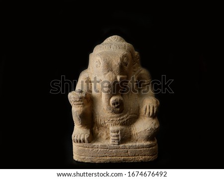 A statue of an Indian god, Lord Ganesha on black background.