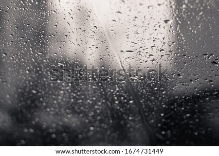 drops after rain on glass. black and white photography. concept art, sad mood. selective focus.