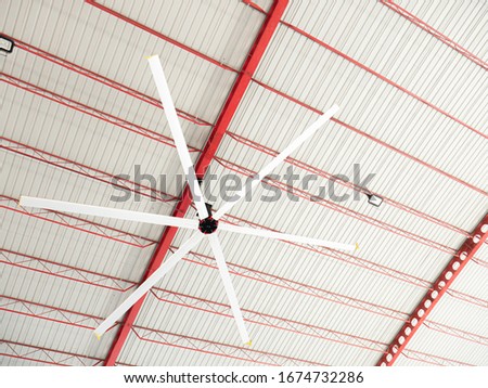 High Volume Low Speed fan "HVLS Ceiling Fan". Big Industrial Fans at roof for hot air cooling and ventilation. Royalty-Free Stock Photo #1674732286