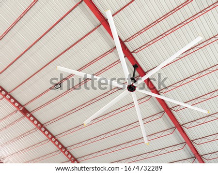 High Volume Low Speed fan "HVLS Ceiling Fan". Big Industrial Fans at roof for hot air cooling and ventilation. Royalty-Free Stock Photo #1674732289