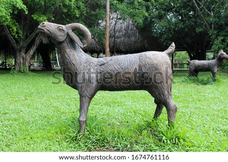 wooden goat on green grass