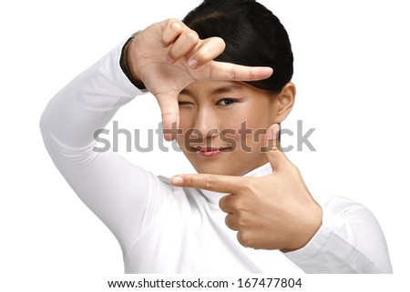 Beautiful asian woman make a frame shot symbol with her hands on white