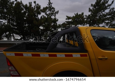 A picture of a yellow car on a beach with a force 10 wind