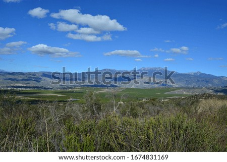 Mostly blue sky with scattered clouds above southern California mountains