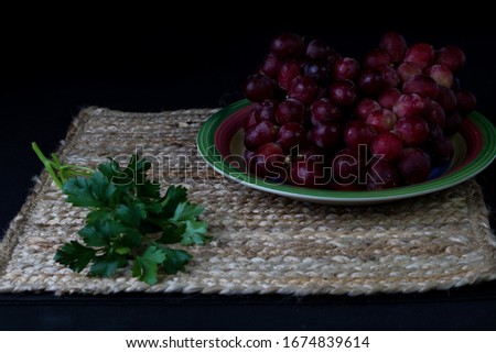 grapes on colorful plate, vegetables, on canvas with black background