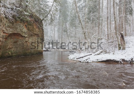 City Ligatne, Latvia. River in winter with sandstone cliffs and caves.14.03.2020